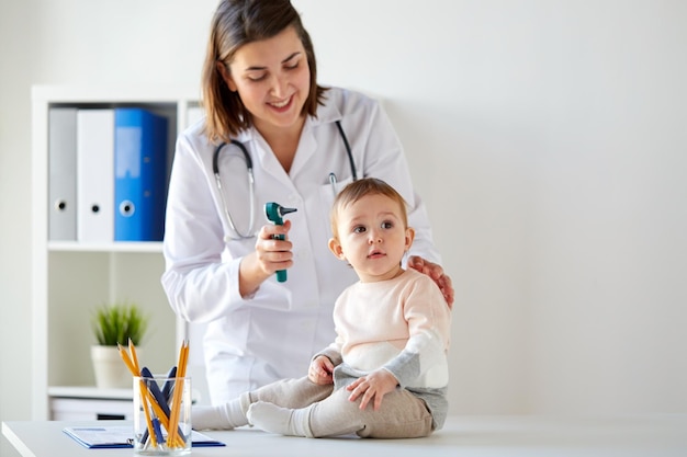 concept de médecine, de soins de santé, de pédiatrie et de personnes - otolaryngologue ou médecin avec bébé et otoscope à la clinique