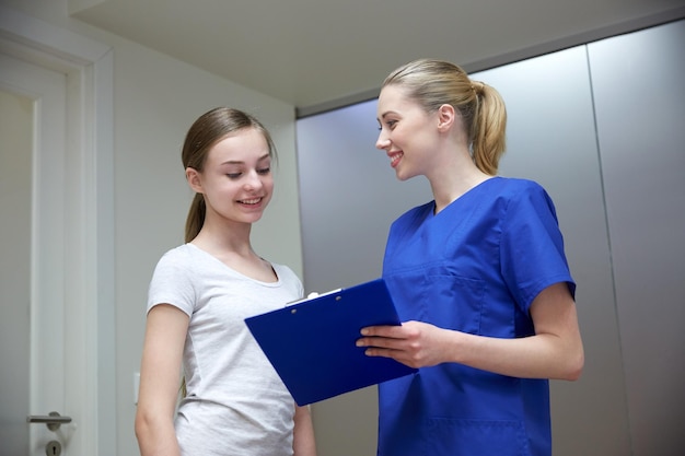 concept de médecine, de soins de santé et de personnes - femme médecin ou infirmière souriante avec presse-papiers et réunion d'une jeune fille à l'hôpital