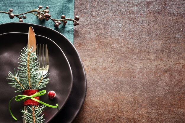 Concept de menu de Noël avec assiettes et couverts noirs décorés