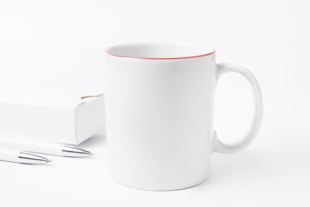 Concept de minimalisme, tasse à café et crayons sur un bureau blanc