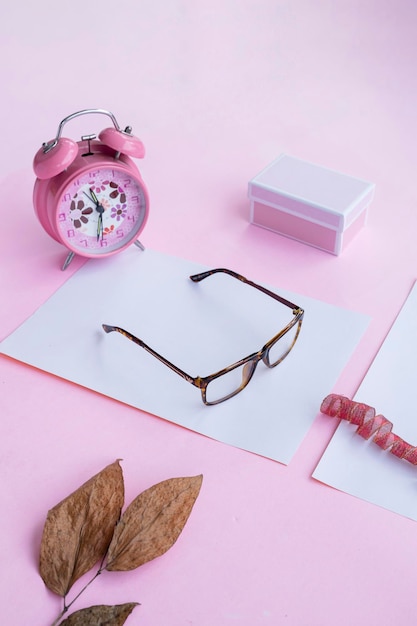 Concept de mode et de beauté à plat avec des accessoires pour femmes lunettes carrées sur fond rose