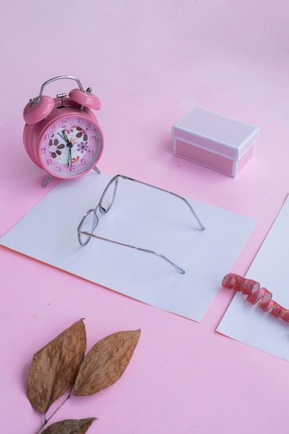 Concept de mode et de beauté à plat avec des accessoires pour femmes lunettes carrées sur fond rose