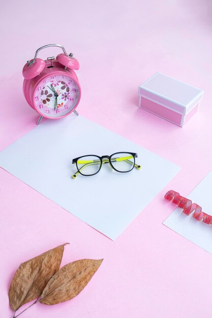 Concept de mode et de beauté à plat avec des lunettes ovales accessoires pour femmes sur fond rose Présentation du produit des idées de concept minimalistes