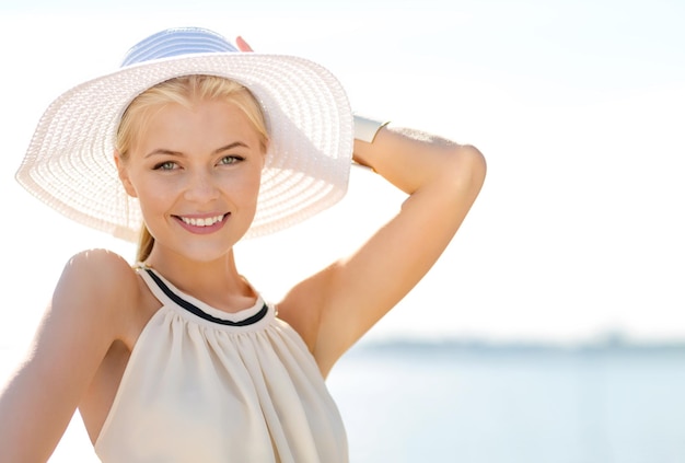 concept de mode, de bonheur et de style de vie - belle femme au chapeau profitant de l'été à l'extérieur