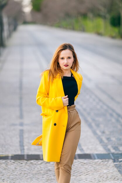 Concept de mode féminine. fille dans un manteau jaune avec un beau m