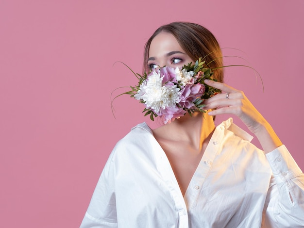 Concept à la mode masque facial portrait de parfum floral frais et vivant en studio sur un fond rose...