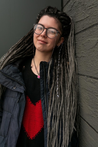 Concept de mode de rue jeune femme européenne avec des dreadlocks portant une veste sombre dans un urbain