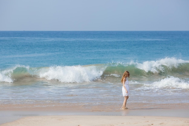 Concept de mode de vacances d'été femme bronzante portant un chapeau de soleil à la plage sur un sable blanc tiré d'en haut