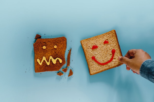 Concept de mode de vie de bonheur. Pose plate de tranches de pain grillé. Une personne a choisi un morceau bien fait avec un visage souriant. le brûlé avec Crazy Face n&#39;est pas Select. Vue de dessus