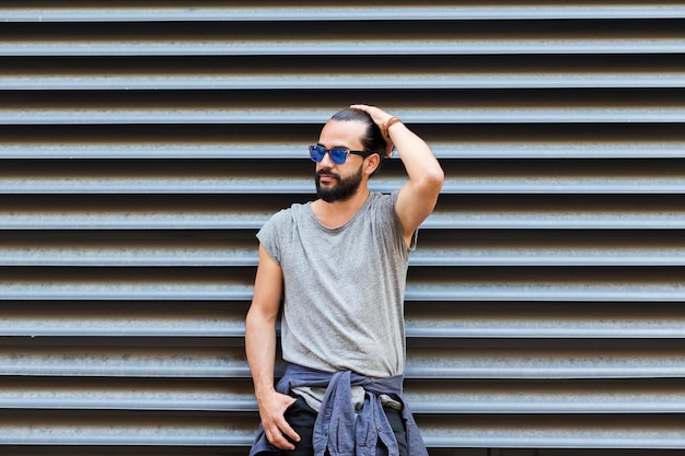 concept de mode de vie, d'émotion, d'expression et de personnes - homme souriant heureux avec des lunettes de soleil et une barbe dans la rue de la ville