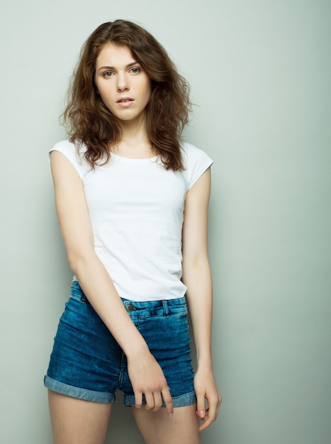 Concept de mode de vie, de mode et de personnes: jeune femme bouclée qui pose en studio, style décontracté, adolescent.