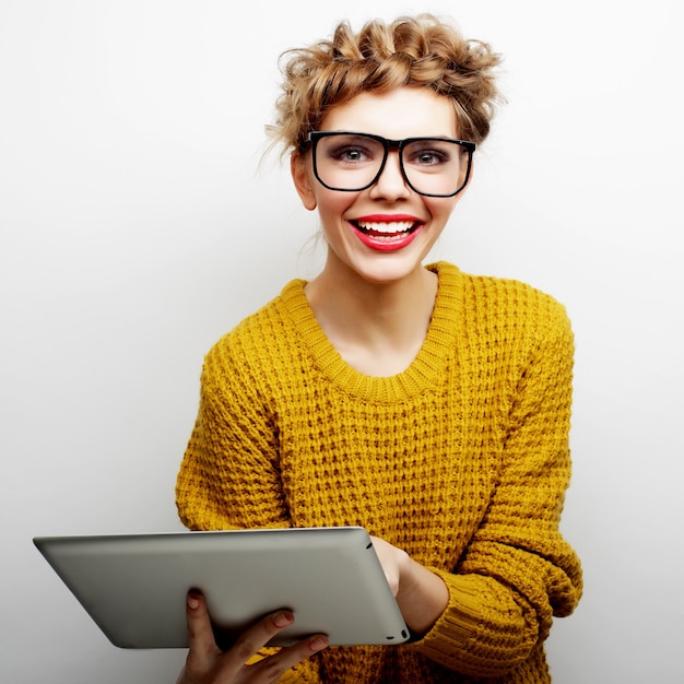 Concept de mode de vie et de personnes : adolescente heureuse portant des lunettes avec un ordinateur tablet pc