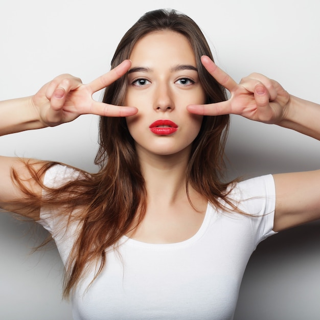 Concept de mode de vie et de personnes : belle femme montrant la victoire ou le signe de paix