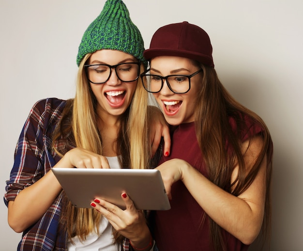 Concept de mode de vie et de personnes : deux amies hipster utilisent une tablette numérique