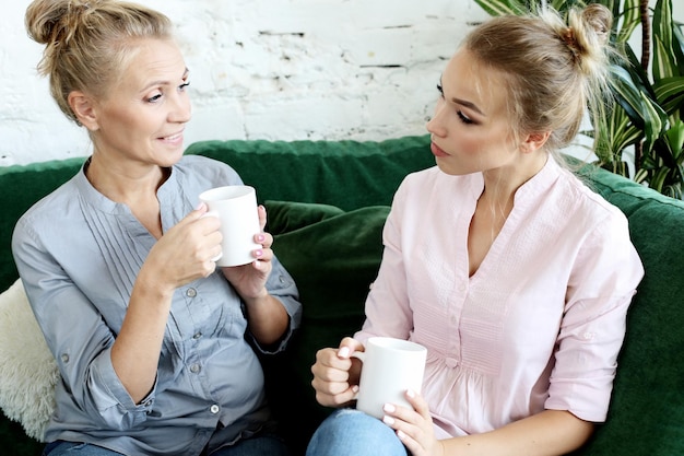 Concept de mode de vie et de personnes Deux belles femmes mère et fille assises sur le canapé à la maison