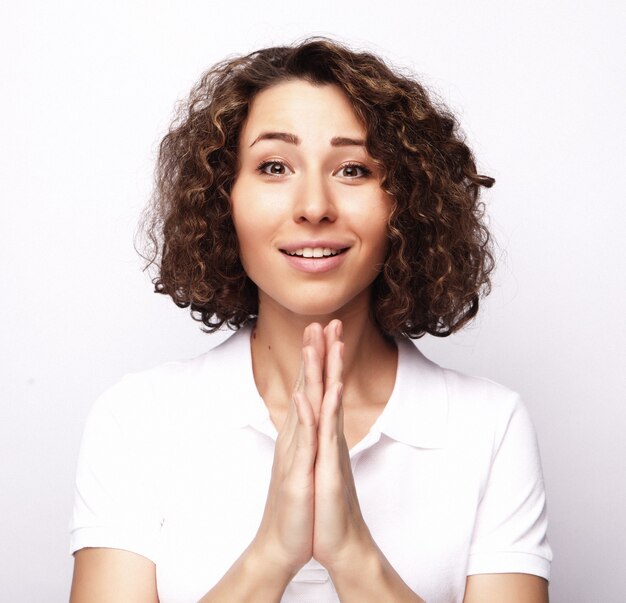 Concept de mode de vie et de personnes: jeune femme heureuse aux cheveux bouclés sur un espace blanc