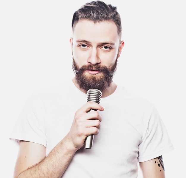 Concept de mode de vie et de personnes jeune homme barbu chantant avec microphone