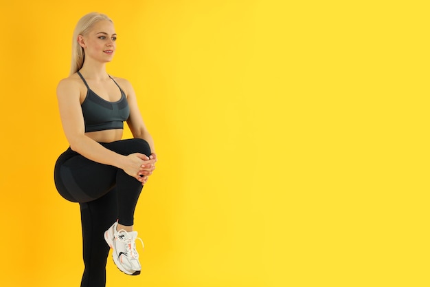 Concept de mode de vie sain avec une femme sportive sur fond jaune