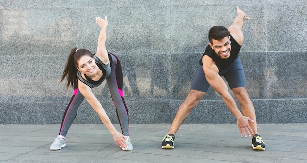 Concept de mode de vie sain. Jeune homme et femme faisant des exercices du matin en plein air, panorama, espace de copie