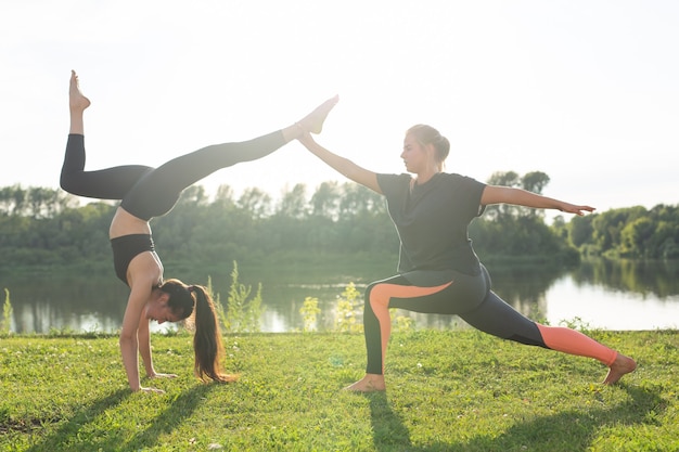 Concept De Mode De Vie Sain Et De Personnes - Femmes Flexibles Faisant Du Yoga Dans Le Parc D'été