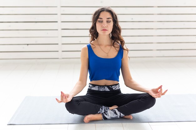 Concept de mode de vie sain, de personnes et de sport. Jolie femme pratiquant le yoga en posture de lotus.