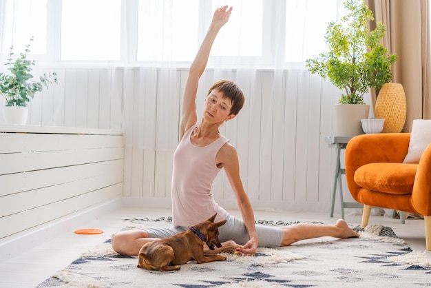 Concept de mode de vie sain Yoga et fitness Jolie femme avec petit chien