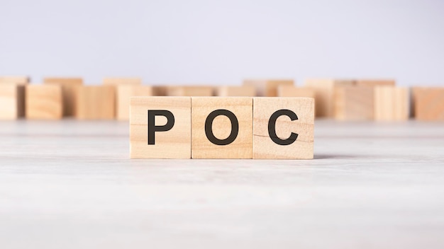 Concept de mot POC écrit sur des cubes ou des blocs de bois sur fond clair