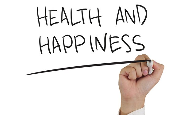 Concept motivationnel image d'un marqueur à la main et écrire Santé et bonheur isolé sur blanc