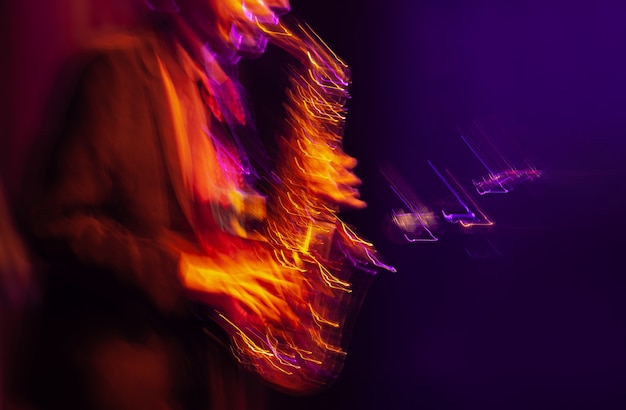 Photo concept de musique jazz. image floue de mouvement abstrait du joueur de saxophone jouant sur scène. le saxophoniste devient fou.