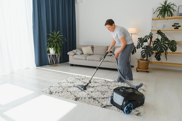 Concept de nettoyage femme nettoyant un tapis avec un aspirateur