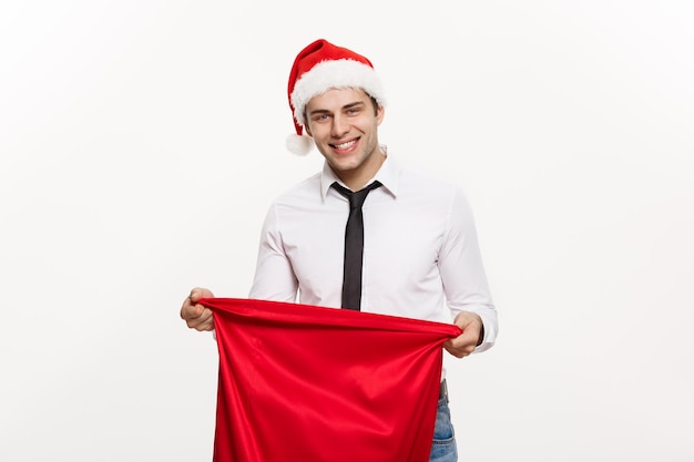 Concept de Noël Bel homme d'affaires célébrer joyeux Noël et bonne année porter chapeau de père Noël avec le grand sac rouge du Père Noël