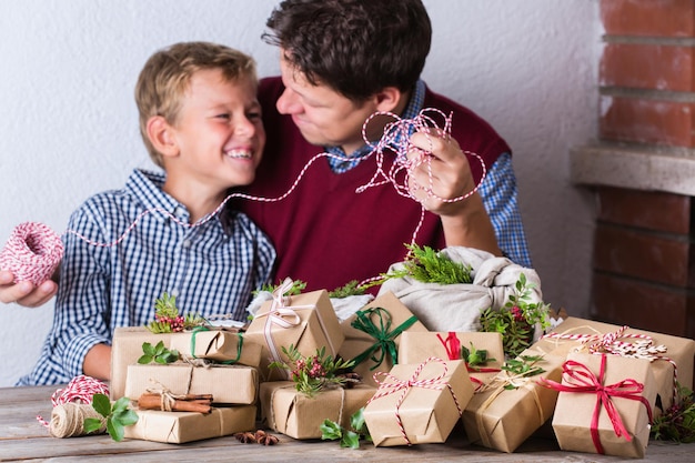 Concept de Noël créatif zéro déchet père et fils emballant des cadeaux