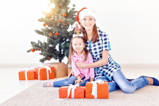 Concept de Noël, de famille et de vacances - Mère et fille festives à la maison dans le salon