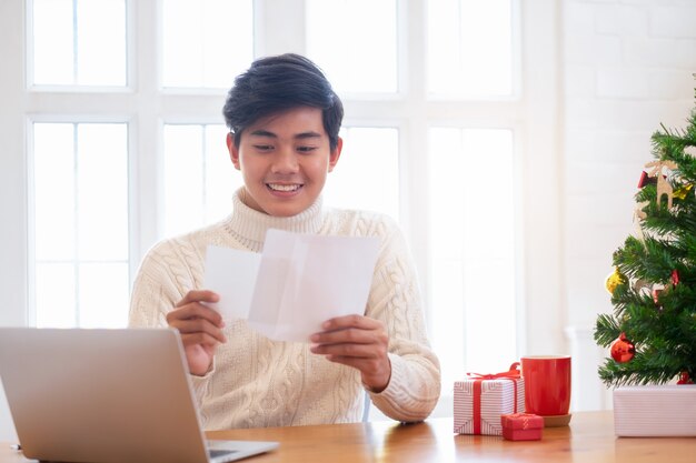 Concept de Noël Homme ouvrant la carte de Noël.