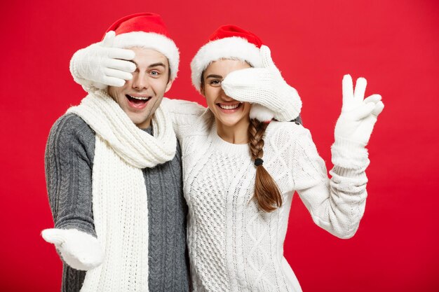 Concept de Noël Jeune couple heureux et élégant en vêtements d'hiver fermer les yeux les uns les autres célébrant le jour de Noël