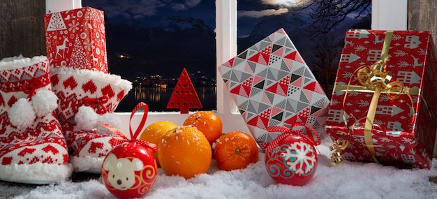 Concept de Noël avec des pantoufles, des oranges et des cadeaux