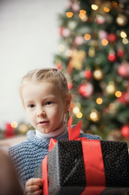 Concept de Noël une petite fille tenant un cadeau