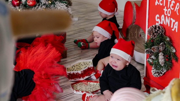 Concept de Noël petits bébés assis sur le tapis l'un d'eux pleure