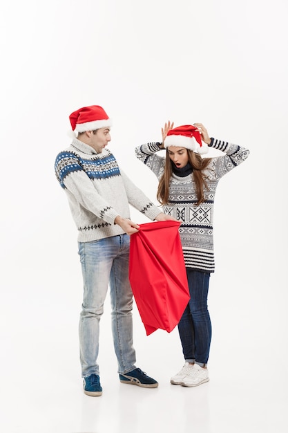 Concept de Noël - pleine longueur jeune couple attractif tenant santa bag isolé sur fond gris blanc.