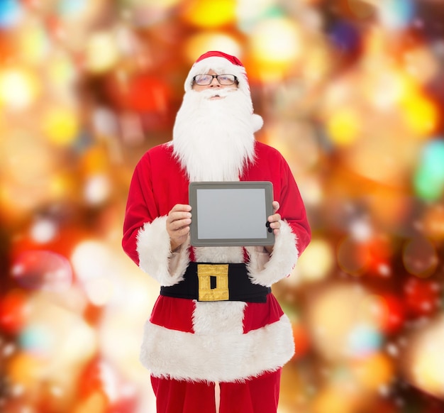 concept de noël, de publicité, de technologie et de personnes - homme en costume de père noël avec ordinateur tablette sur fond de feux rouges