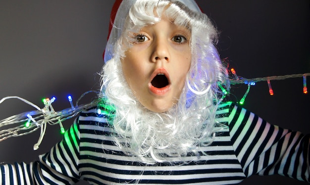 Concept de Noël saisonnier avec garçon surpris en costume de père Noël