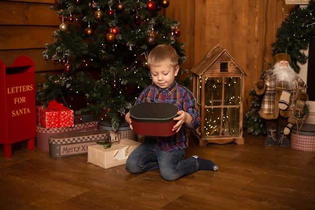Concept de Noël, vacances et enfance - garçon souriant avec boîte-cadeau à la maison