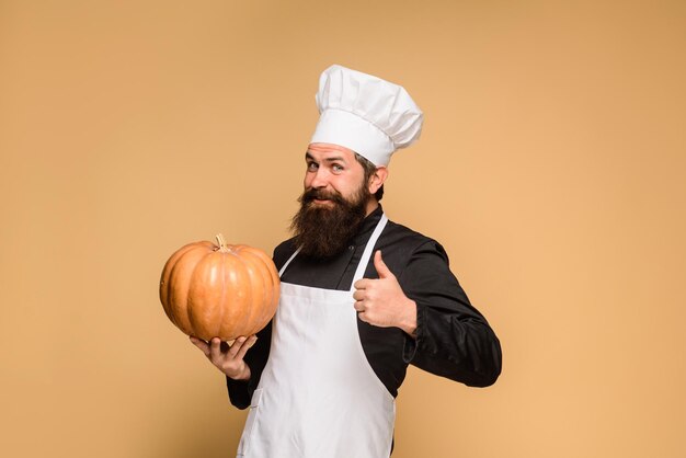 Concept de nourriture d'automne sain récolte organique légumes chef homme en tablier blanc présentant citrouille