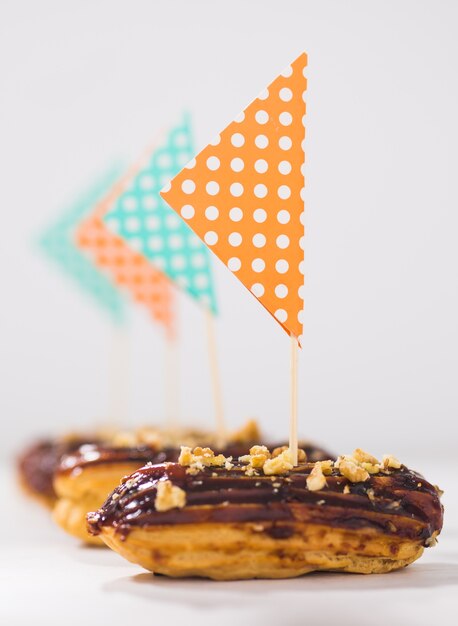 Concept de nourriture, de desserts et de boulangerie - Eclairs au chocolat décorés comme un navire.