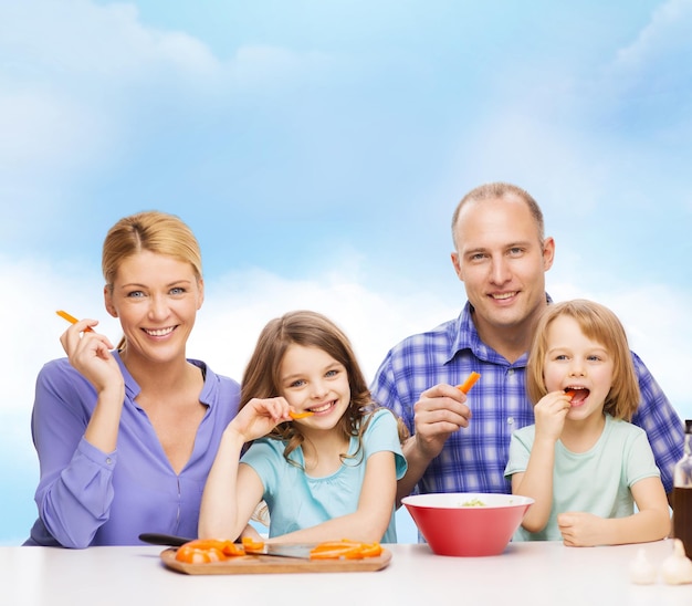 concept de nourriture, de famille, d'enfants, de bonheur et de personnes - famille heureuse avec deux enfants mangeant à la maison
