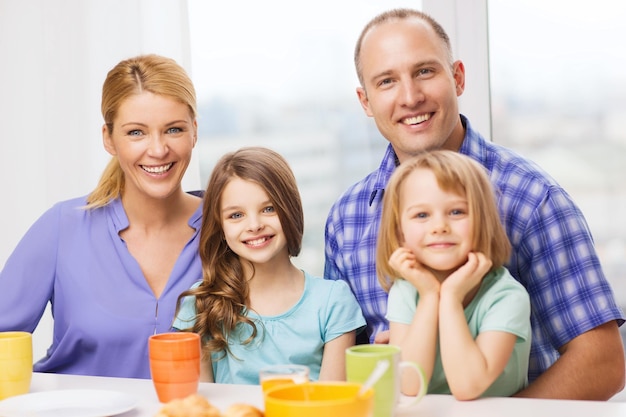 concept de nourriture, de famille, d'enfants, de bonheur et de personnes - famille heureuse avec deux enfants prenant son petit déjeuner à la maison