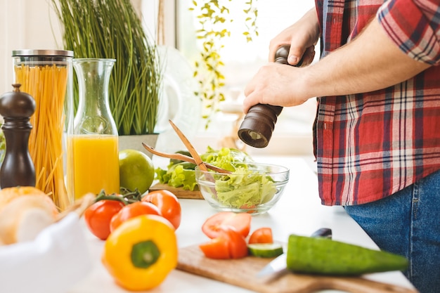 Concept de nourriture en gros plan. Jeune beau couple cuisiner ensemble dans leur cuisine à la maison.