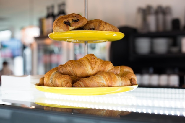 concept de nourriture, de pâtisserie, de malbouffe et de mauvaise alimentation - gros plan de croissants et de petits pains sur un stand de gâteau au café ou à la boulangerie