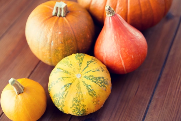 concept de nourriture, de récolte, de saison et d'automne - gros plan de citrouilles sur une table en bois à la maison