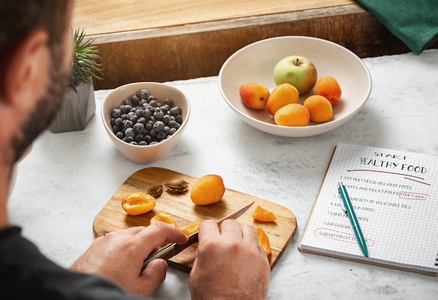 Concept de nourriture de régime. Homme cuisiner des aliments sains dans la cuisine